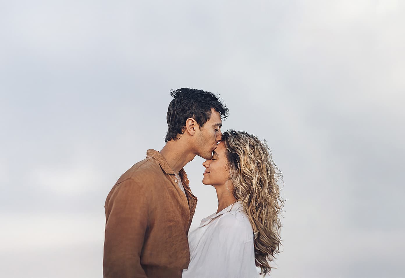 a happy couple smiling face to face outdoors in the sun